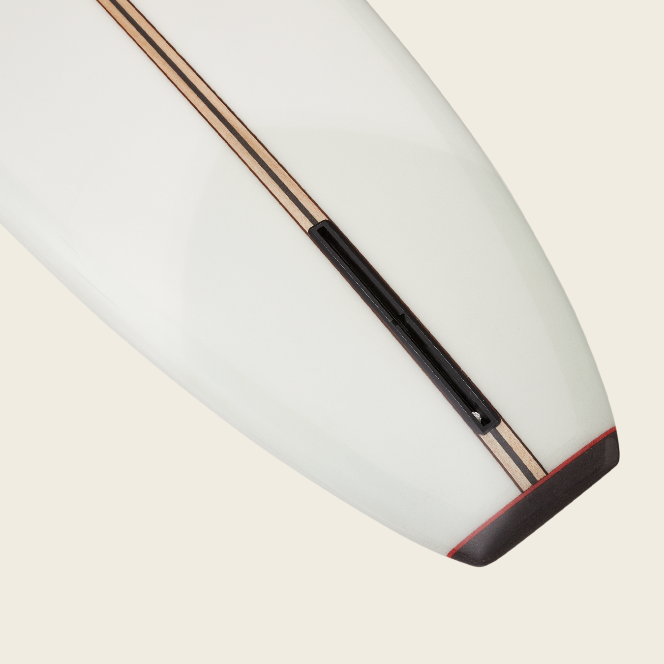 Close-up of the tail end of a traditional surfboard, featuring wood stringer details and a black fin box—this classic design is ideal for noseriding, inspired by the iconic Bing Noserider style.