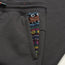 Close-up of dark gray Mellow Mono Sweatpants featuring a pocket with colorful, geometric patterned trim in blue, orange, green, pink, yellow, and white and a comfortable drawstring waistband.