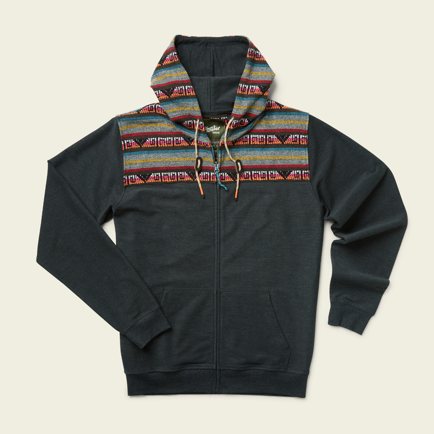 A dark gray cotton blend hoodie with a woven jacquard yoke featuring colorful stripes and geometric designs across the shoulders and hood. The hoodie has long sleeves, front pockets, and vibrant Baja hoodie-inspired patterns.