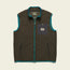A dark green Chisos Fleece Vest with teal trim, made from high pile fleece. This lightweight vest features a front zipper, two zippered hand pockets, and a black chest pocket with a button and rectangular Howler Bros logo patch.