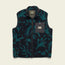 The Chisos Fleece Vest is a lightweight vest featuring a dark blue and teal leafy pattern, high pile fleece, a full front zipper, high collar, and a gray chest pocket with a rectangular “Howler Bros” logo patch.
