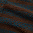 Close-up of a high pile fleece fabric with a fluffy, fleece-like surface. The material, ideal for a casual jacket or fleece overshirt, features alternating dark brown and teal geometric patterned stripes. One black button is partially visible in the upper left corner.