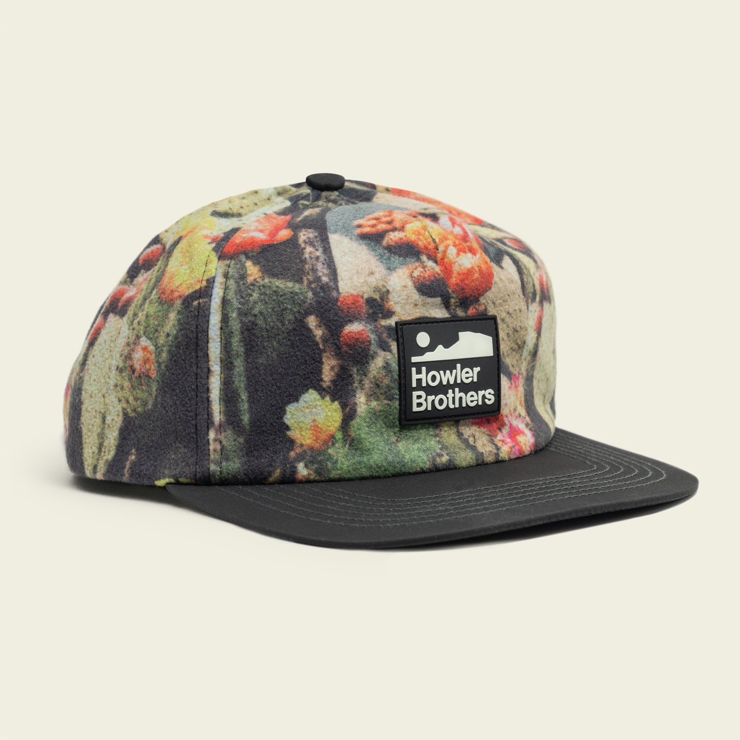 A five-panel cap featuring a colorful nature-inspired pattern, a pliable brim, an adjustable snapback closure, and a rectangular Howler Brothers logo patch on the front.