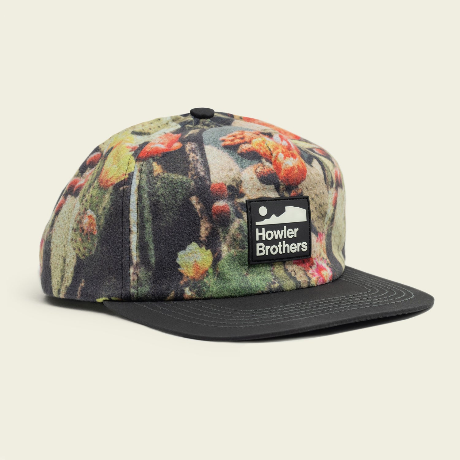 A five-panel cap featuring a colorful nature-inspired pattern, a pliable brim, an adjustable snapback closure, and a rectangular Howler Brothers logo patch on the front.