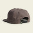 A brown unstructured snapback cap shown from the back, featuring a soft crown, a black adjustable snapback closure, and a small tag with a white logo near the closure, all set against a plain light background.