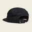 A black baseball cap shown from the back, featuring an adjustable strapback closure with a buckle and a small tag displaying a stylized face logo. The unstructured strapback design offers a soft crown. The background is a plain off-white color.
