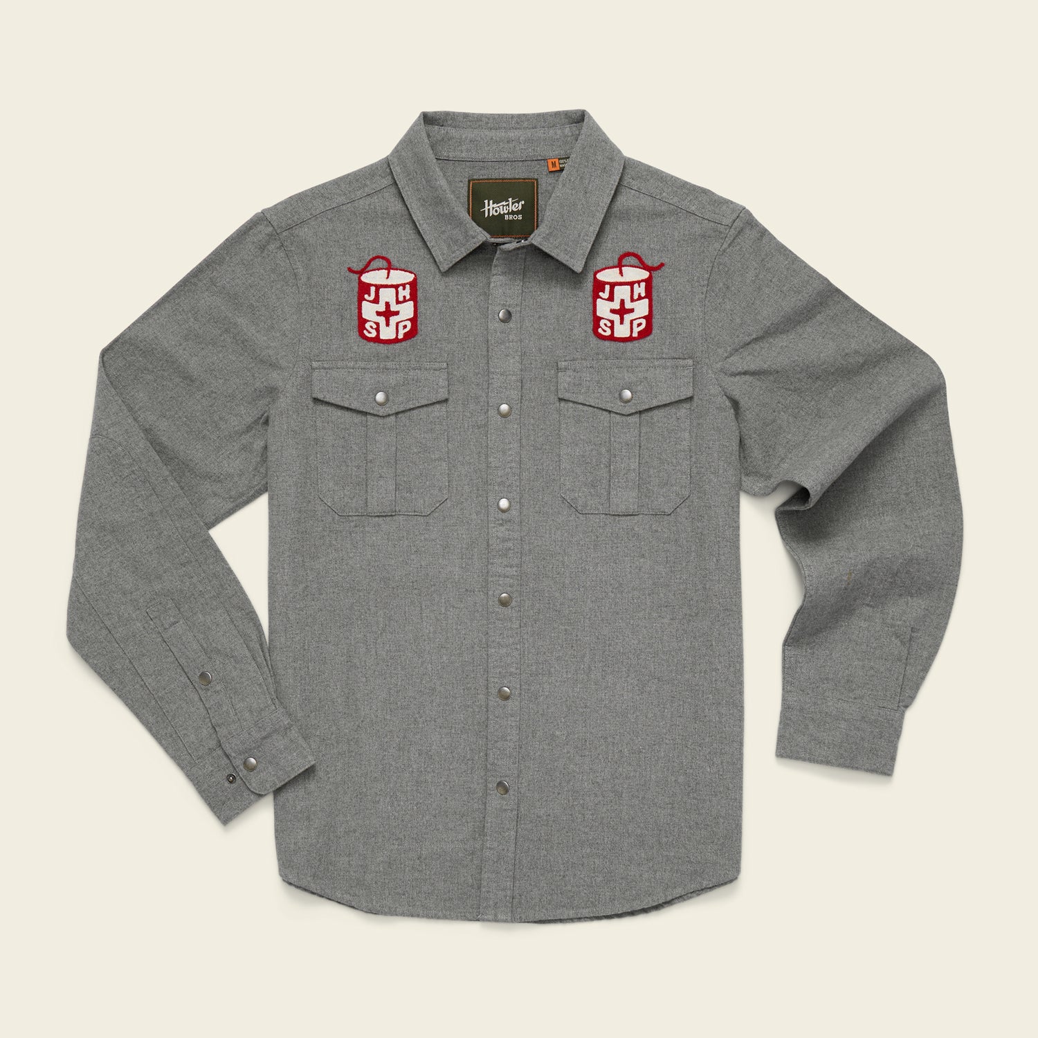 Gray Gaucho Snapshirt with long sleeves, button-up front, two pockets, and red and white embroidered patches above each pocket, displayed on a light background.
