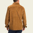 A man is shown from the back wearing a brown wide wale corduroy button-up shirt and dark pants, standing against a plain light background.