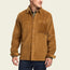 A man wearing a tan wide wale corduroy Iquitos Overshirt with a front chest pocket, layered over a green shirt and dark pants. He stands with his head turned slightly to the side—a perfect travel shirt look.
