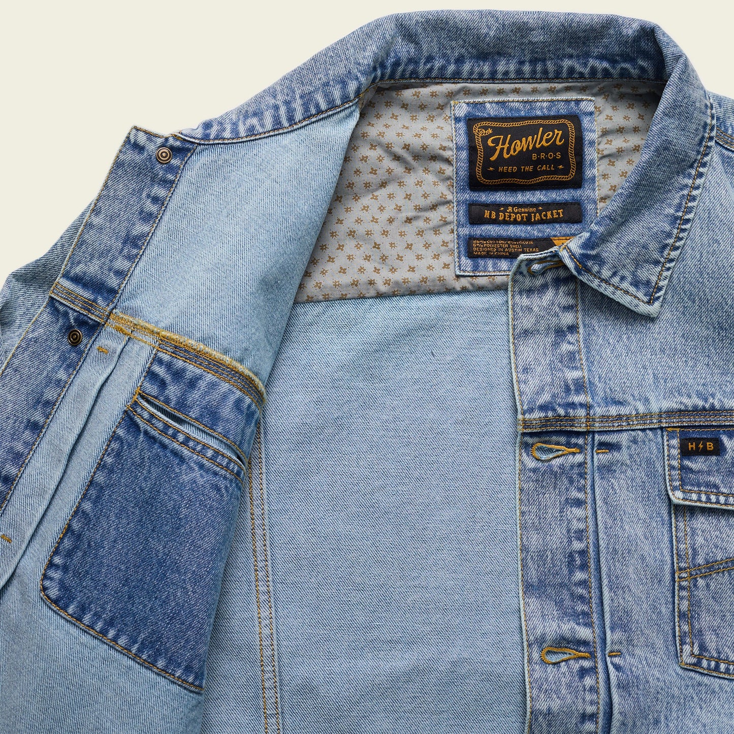 A light blue Depot Jacket with visible lightning bolt stitching, a patterned inner lining, and a Howler Bros label on the collar. The denim jacket is partially open, revealing the interior and multiple pockets.