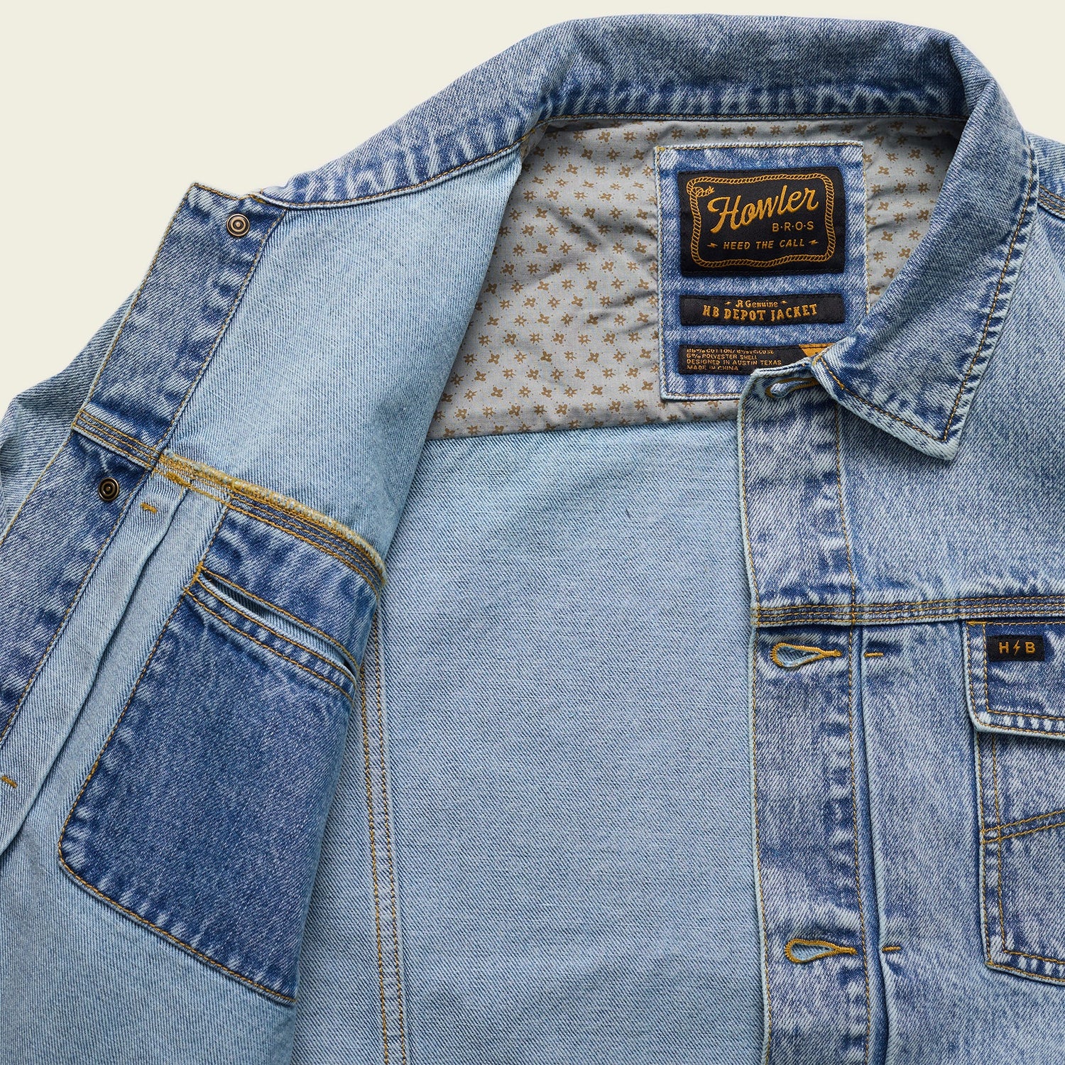 A light blue Depot Jacket with visible lightning bolt stitching, a patterned inner lining, and a Howler Bros label on the collar. The denim jacket is partially open, revealing the interior and multiple pockets.