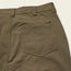 olive green Tech Pants laid out flat, showcasing the 5-pocket design.