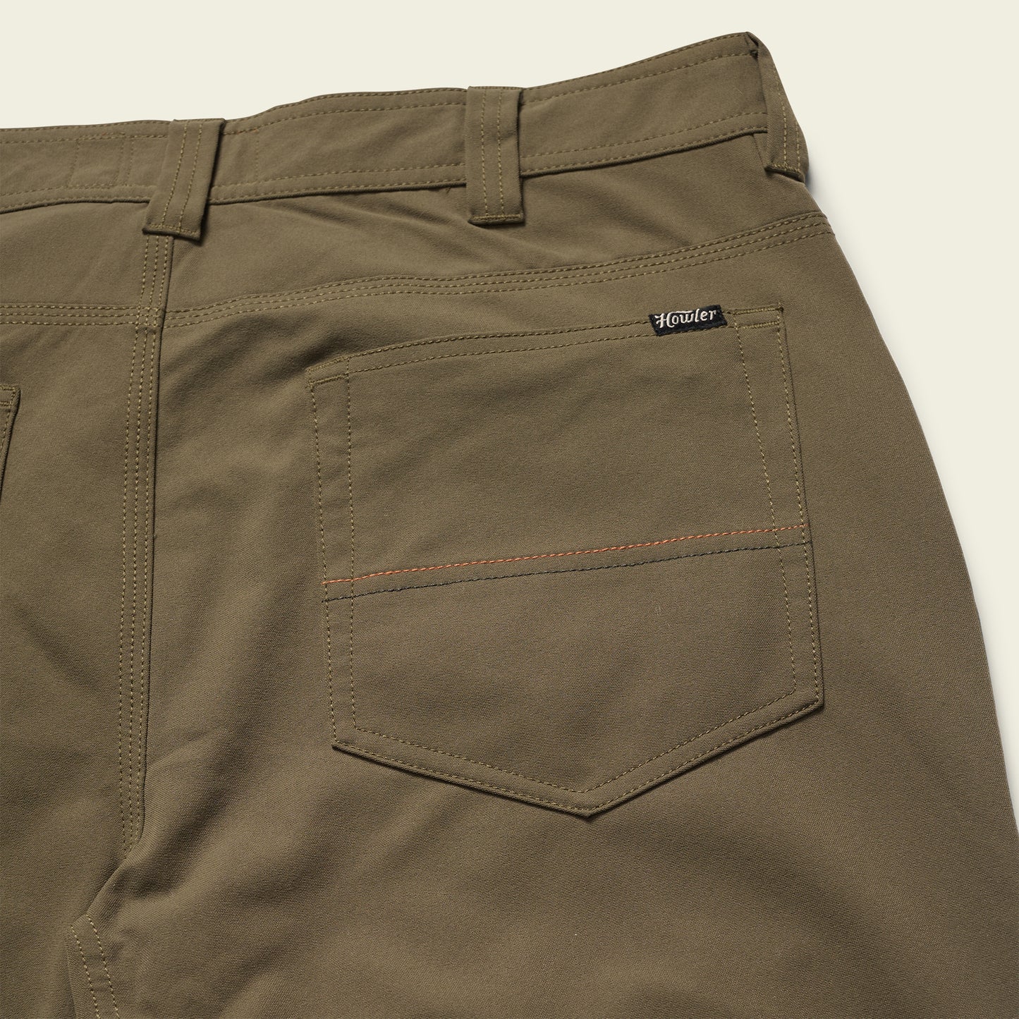 olive green Tech Pants laid out flat, showcasing the 5-pocket design.