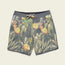Green swim trunks with a drawstring waist featuring a vibrant cactus and blooming yellow flower print on a light background. The Hecho brand label sits near the hem, and draining front pockets offer added convenience.