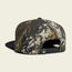 A snapback cap with a camouflage pattern is shown from the back, featuring an adjustable snapback closure, a small black tag near the opening, and a soft crown for added comfort.