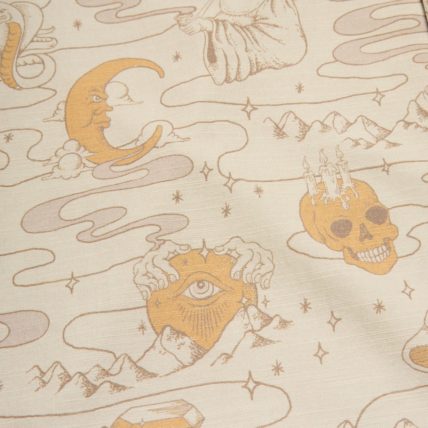 Beige slub fabric with mystical illustrations—moon face, all-seeing eye, skull with castle, stars, and more—in a vintage style reminiscent of classic camp collar shirts.