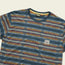 A blue patterned jacquard t-shirt with horizontal geometric and colorful stripe designs, a round neckline, and a small palm tree patch on the left chest. The vintage surf t-shirt style features the Hustler label inside the collar.