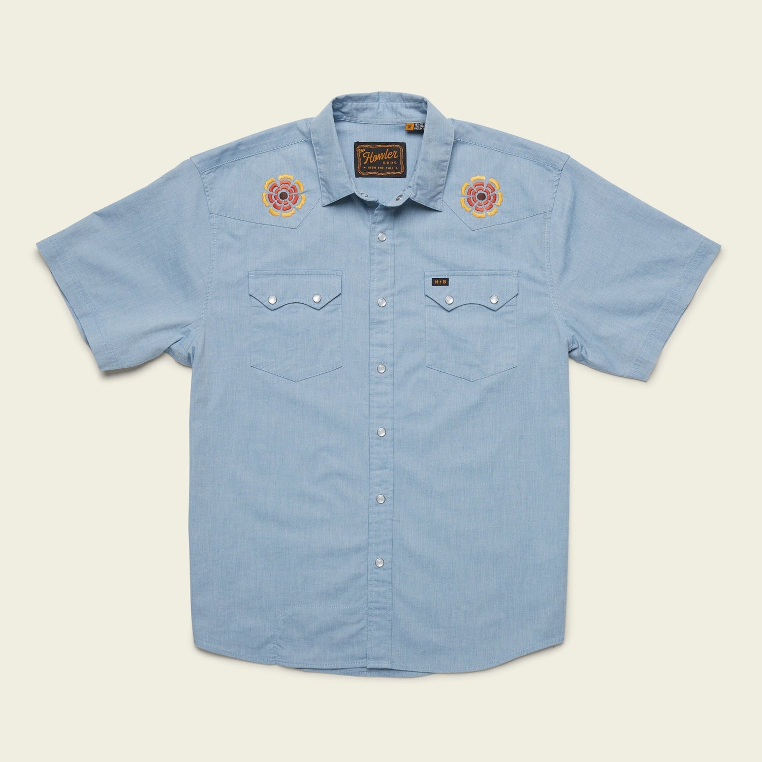 Light blue Crosscut Deluxe Shortsleeve shirt with two chest pockets and motif embroidery of roses on each shoulder. This summer shirt features a casual, western-inspired style and is displayed on a plain background.