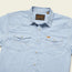 A light blue short-sleeve snapshirt with two front chest pockets, decorative stitching, and a collar. The shirt features pearl snaps and a brown Howler H Bar B brand label on the inside collar.