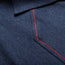 Close-up of a blue denim fabric with a collar and red zigzag stitch along the seam, highlighting western yokes that create contrast with the blue 100% cotton material.