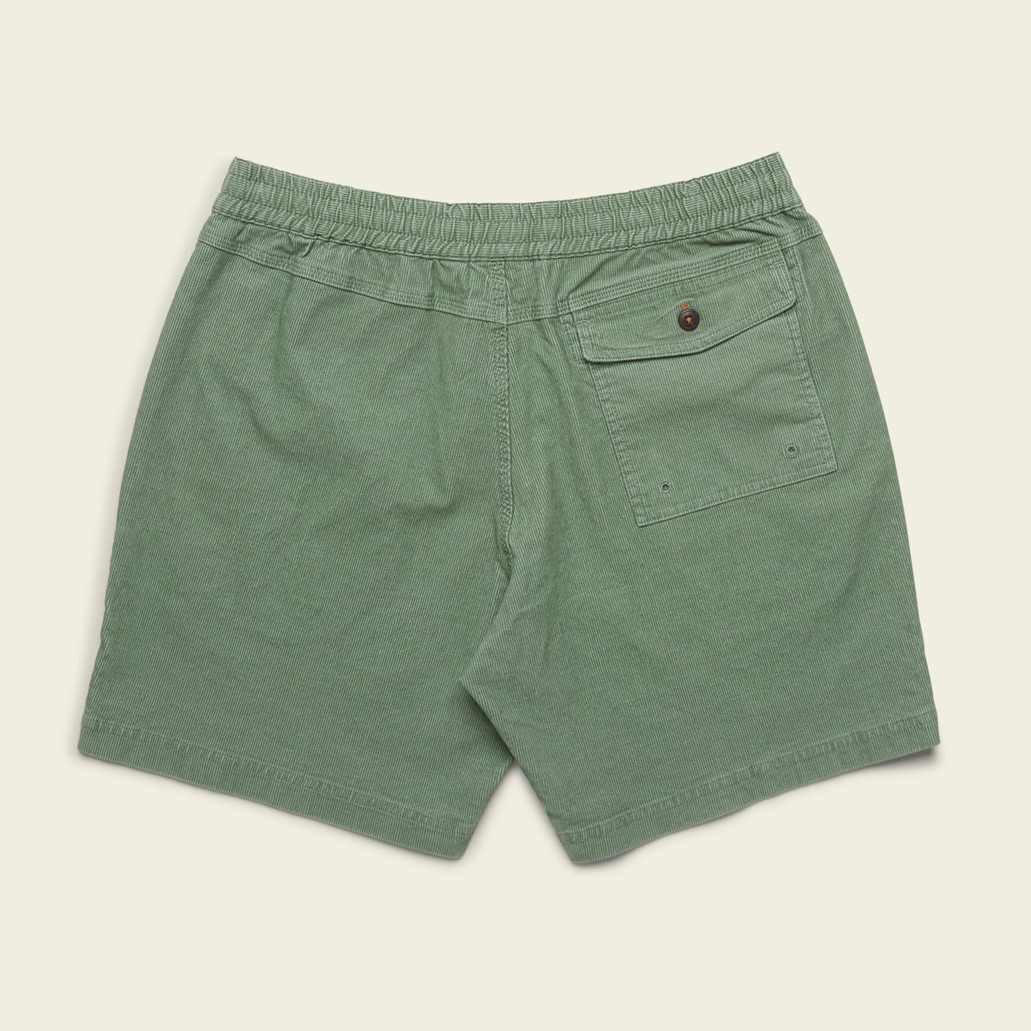 Green Pressure Drop Cord Shorts made from stretch cotton corduroy, featuring an elastic waistband, a single back pocket with button closure, and two small metal eyelets on the pocket, laid flat on a beige background.