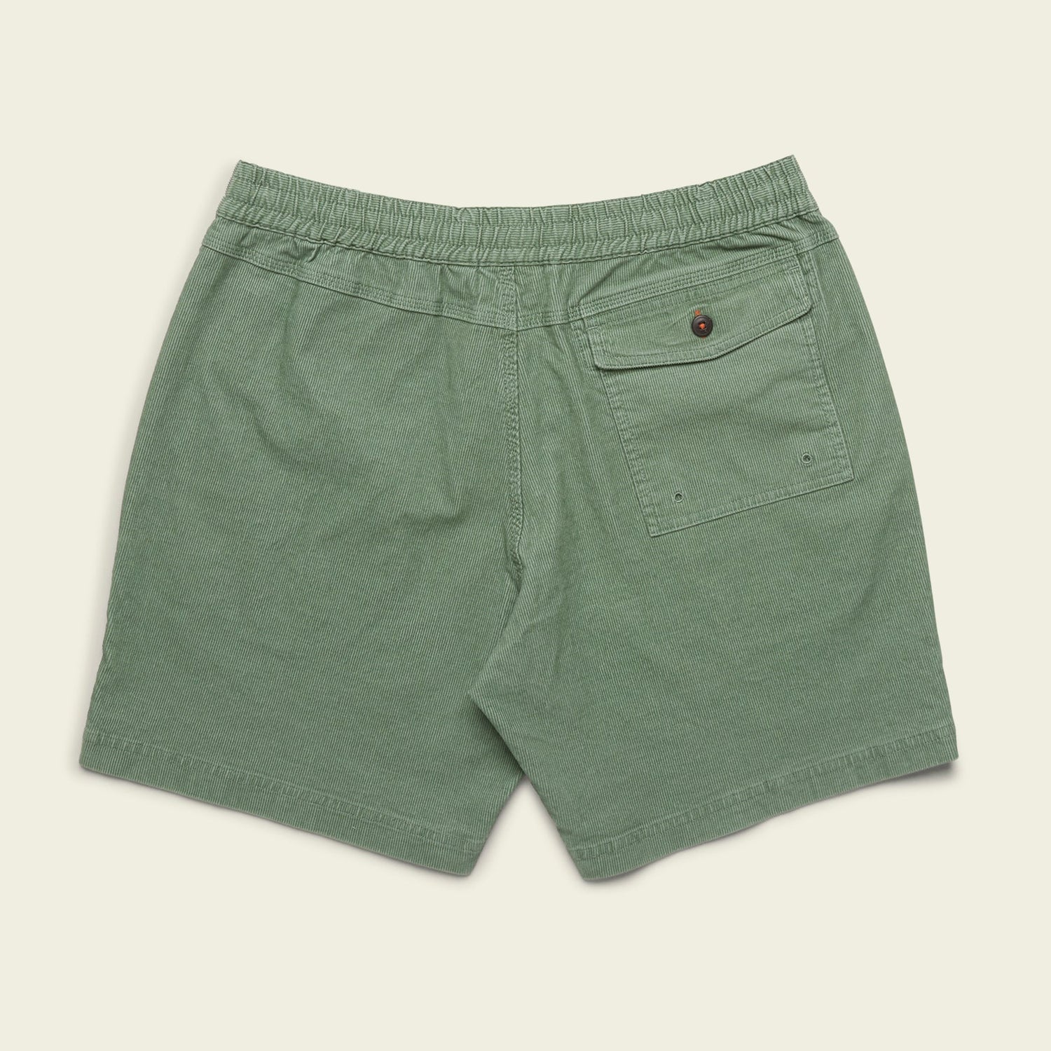 Green Pressure Drop Cord Shorts made from stretch cotton corduroy, featuring an elastic waistband, a single back pocket with button closure, and two small metal eyelets on the pocket, laid flat on a beige background.