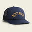 A navy blue, vintage-inspired hat with a foam front and black mesh back features the word HOWLER in curved yellow letters on the front panel. The high crown hat is displayed on a light background.