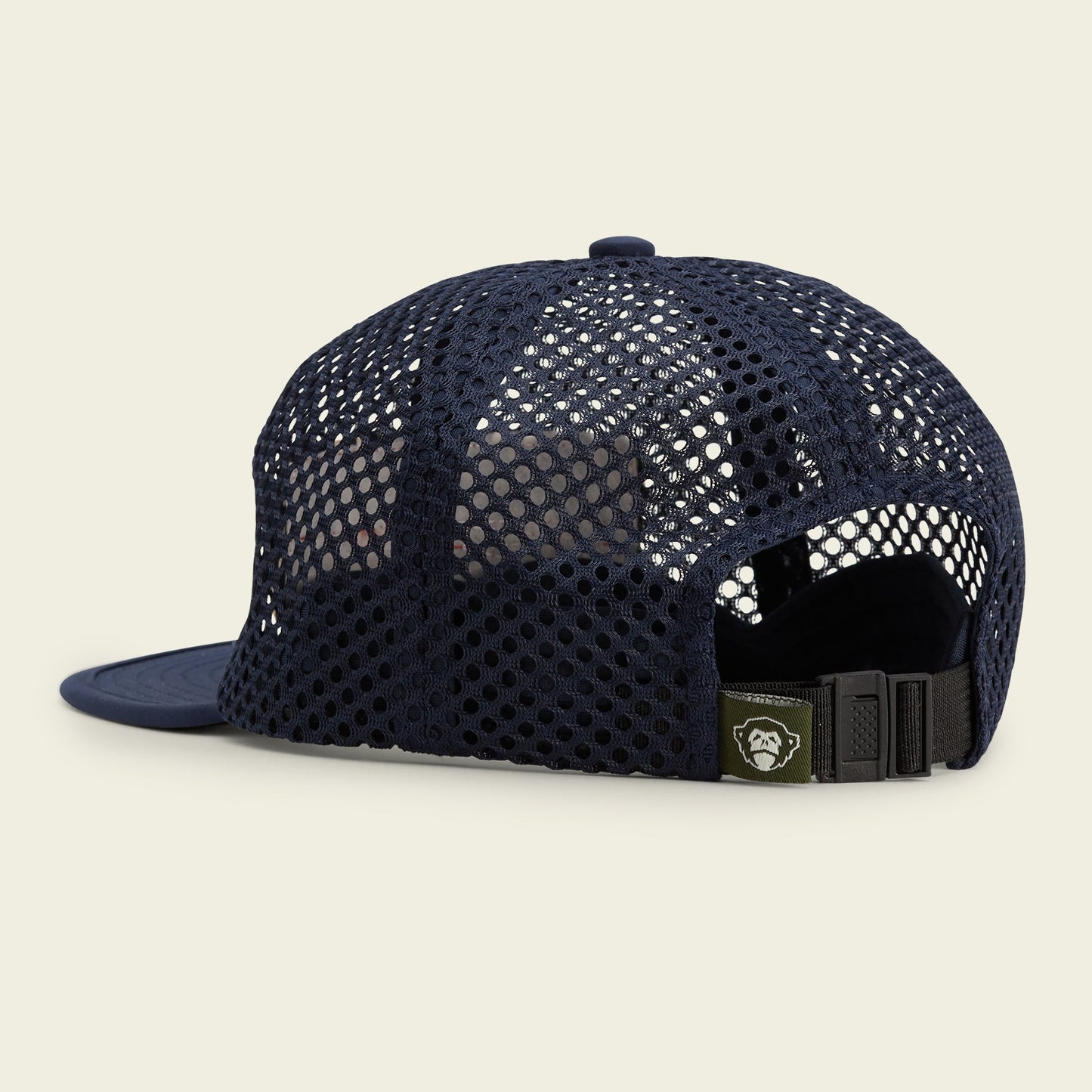 A navy blue mesh tech hat shown from the back, featuring an adjustable strap with a buckle and a small green tag with a white logo. The cap boasts a ventilated, breathable, and quick-drying design for versatile cover.