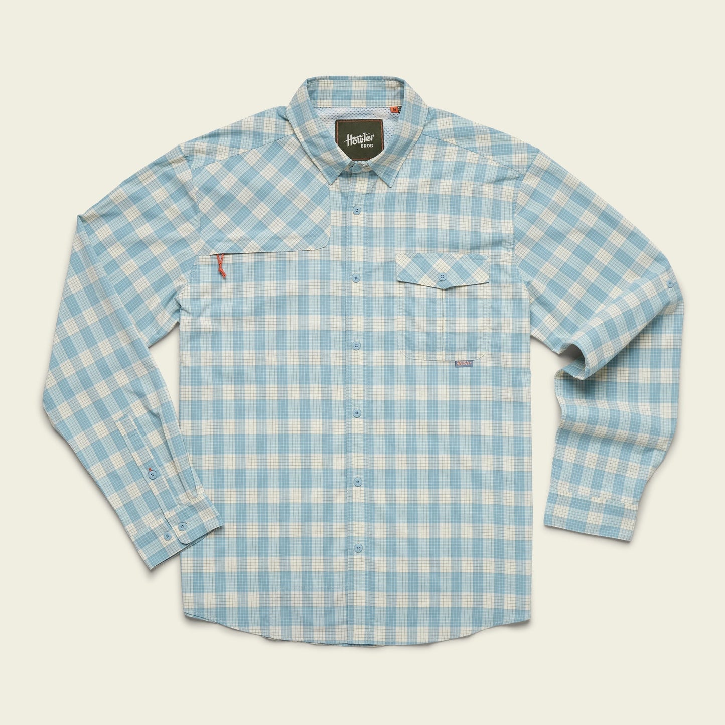 A long-sleeve, button-up Matagorda Shirt featuring a blue and white plaid pattern, chest flap pocket with an extra zipper pocket above, and buttoned cuffs. This quick-drying travel shirt is laid flat on a light background.