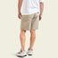 A person wearing a white t-shirt, cotton twill shorts with back pockets, and white sneakers with maroon and teal accents stands with their back facing the camera.
