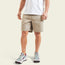 A person wearing a white t-shirt and cotton twill shorts with a hidden snap pocket, paired with white sneakers featuring teal and maroon accents, stands against a plain light background. Only the lower half of the body is visible.