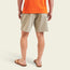 A person stands facing away, wearing an orange t-shirt and Pressure Drop Cord Shorts made from stretch cotton corduroy with an elastic waistband, plus brown flip-flops, all set against a light background.