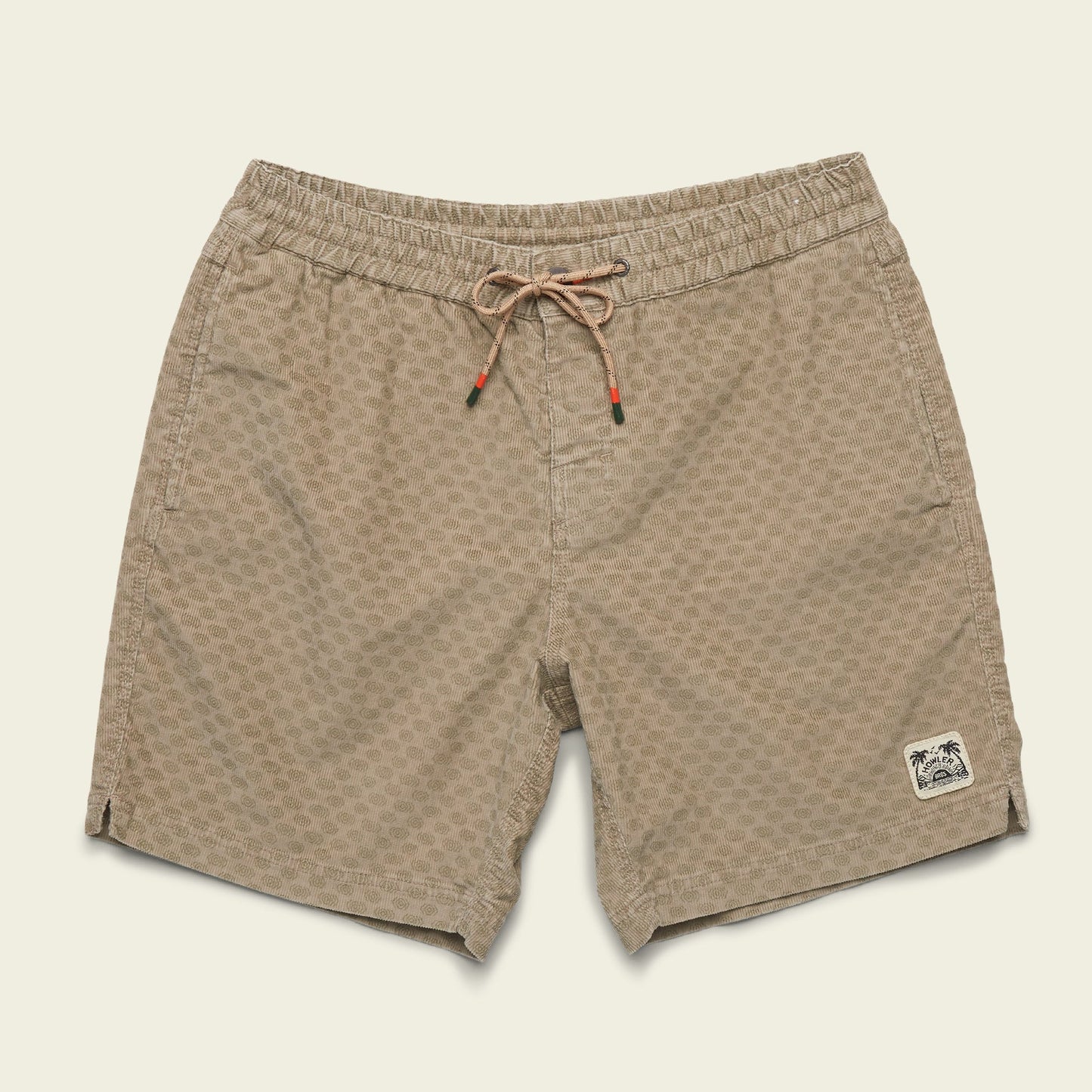 Tan patterned Pressure Drop Cord Shorts featuring an elastic waistband, drawstring, and a small palm tree patch on the left leg, crafted from stretch cotton corduroy and displayed on a plain off-white background.
