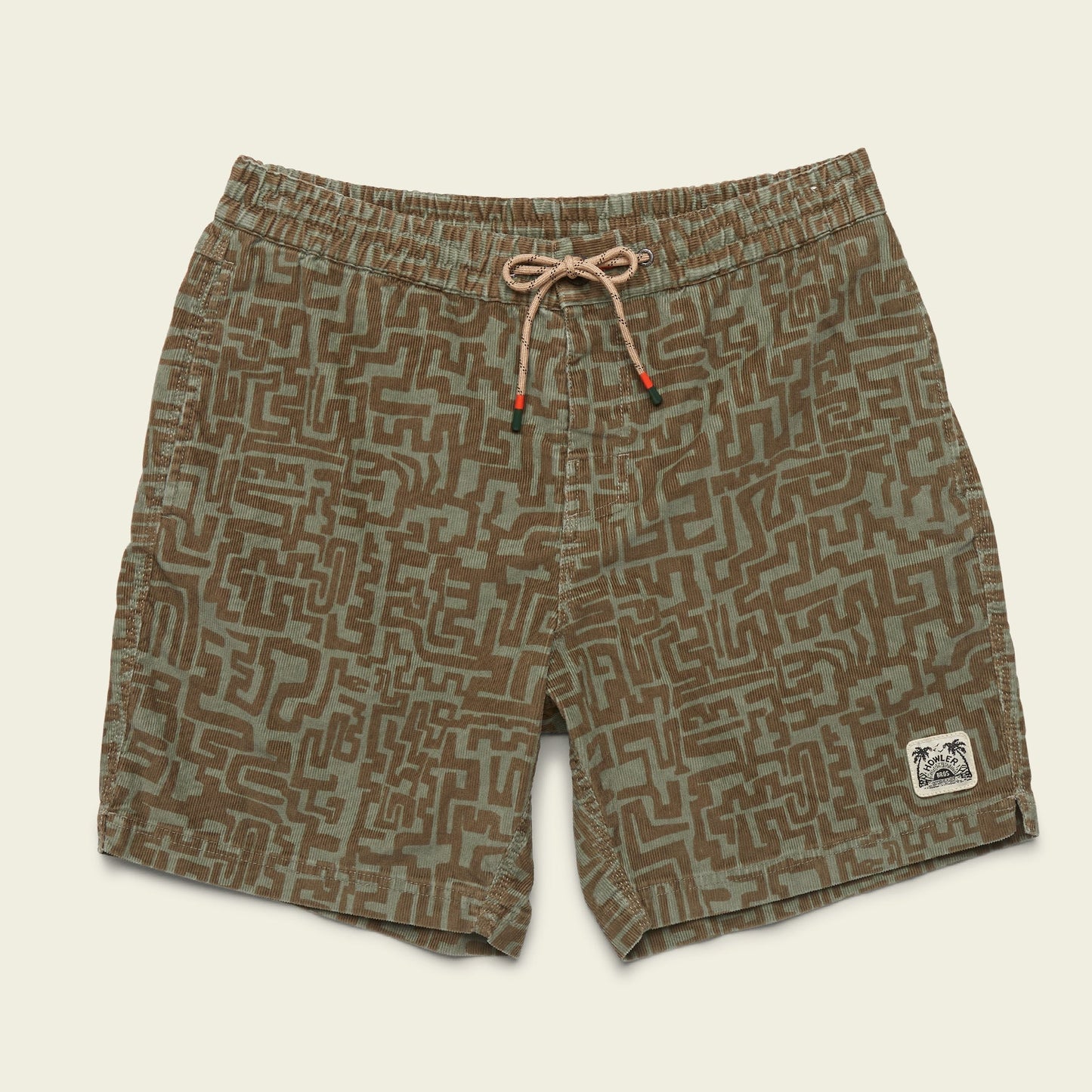 Green and brown patterned Pressure Drop Cord Shorts, crafted from stretch cotton corduroy for all day comfort. Features an elastic waistband, tan drawstring, and a small patch graphic on the bottom left leg, laid flat on a light background.
