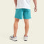 A person stands facing away, wearing a white T-shirt, quick drying nylon running and hiking shorts in teal, and white sneakers with maroon accents, set against a light background.