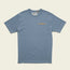 A blue, vintage inspired t-shirt made from heavyweight cotton, featuring a chest pocket adorned with a horizontal row of small, colorful geometric shapes.