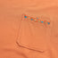 A close-up of an orange pocket t-shirt made from heavyweight cotton, featuring a row of small, colorful embroidered triangles along the top edge for an 80s 90s inspired touch.