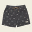Dark gray boardshorts featuring a 7” inseam, tan drawstring, and small white abstract patterns throughout. An elastic waistband ensures comfort, while a rectangular patch with “Howler” is sewn near the lower left hem.