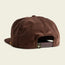 A brown corduroy unstructured snapback baseball cap shown from the back, featuring a pliable brim, an adjustable snapback closure, and a small green tag with a white ape face logo.