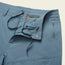 A close-up view of light blue Amphibious Pants, featuring a partially open zipper, button closure, and an adjustable drawstring waistband with visible front pockets and stitching details.