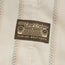 A fabric patch featuring a vintage Toyota Land Cruiser grille design and the text “Toyota Land Cruiser” and “Howler Brothers,” sewn onto a beige cloth with a pastel striped pattern, perfect for fans of vintage inspired shirts.