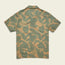 A short-sleeve button-up Monoloha Shirt with a tan background, featuring an all-over green tropical leaf print, displayed flat with the back facing up—perfect for fans of vintage Hawaiian shirts.