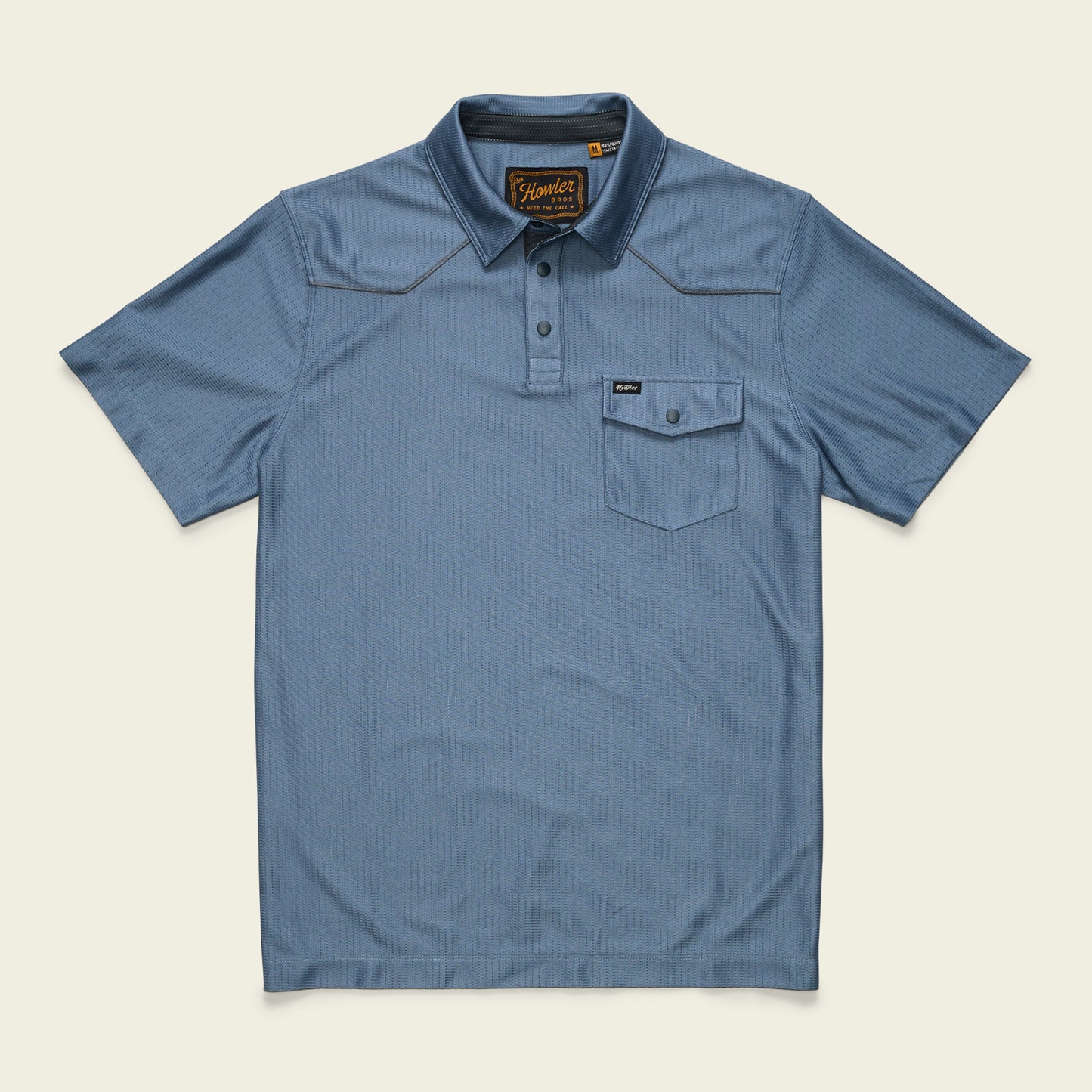 A short-sleeve, light blue Tech Polo made from breathable recycled polyester, featuring a front chest pocket, three buttons, and brown stitching accents, laid flat on a cream background.