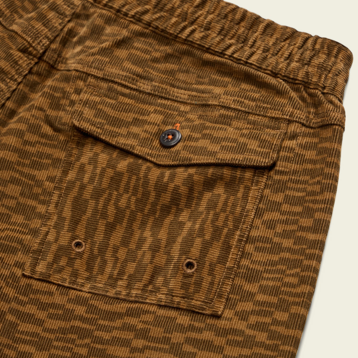 Close-up of Pressure Drop Cord Shorts in stretch cotton corduroy, featuring a flap pocket with a black button and two metal eyelets, showcasing a textured, striped pattern and an elastic waistband for ultimate comfort.
