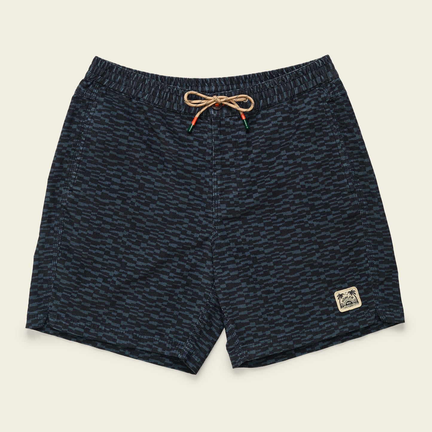 Navy blue swim trunks with a subtle wave pattern, an elastic waistband with a tan drawstring, and a small patch featuring palm trees and waves on the front left leg deliver all day comfort inspired by Pressure Drop Cord Shorts.
