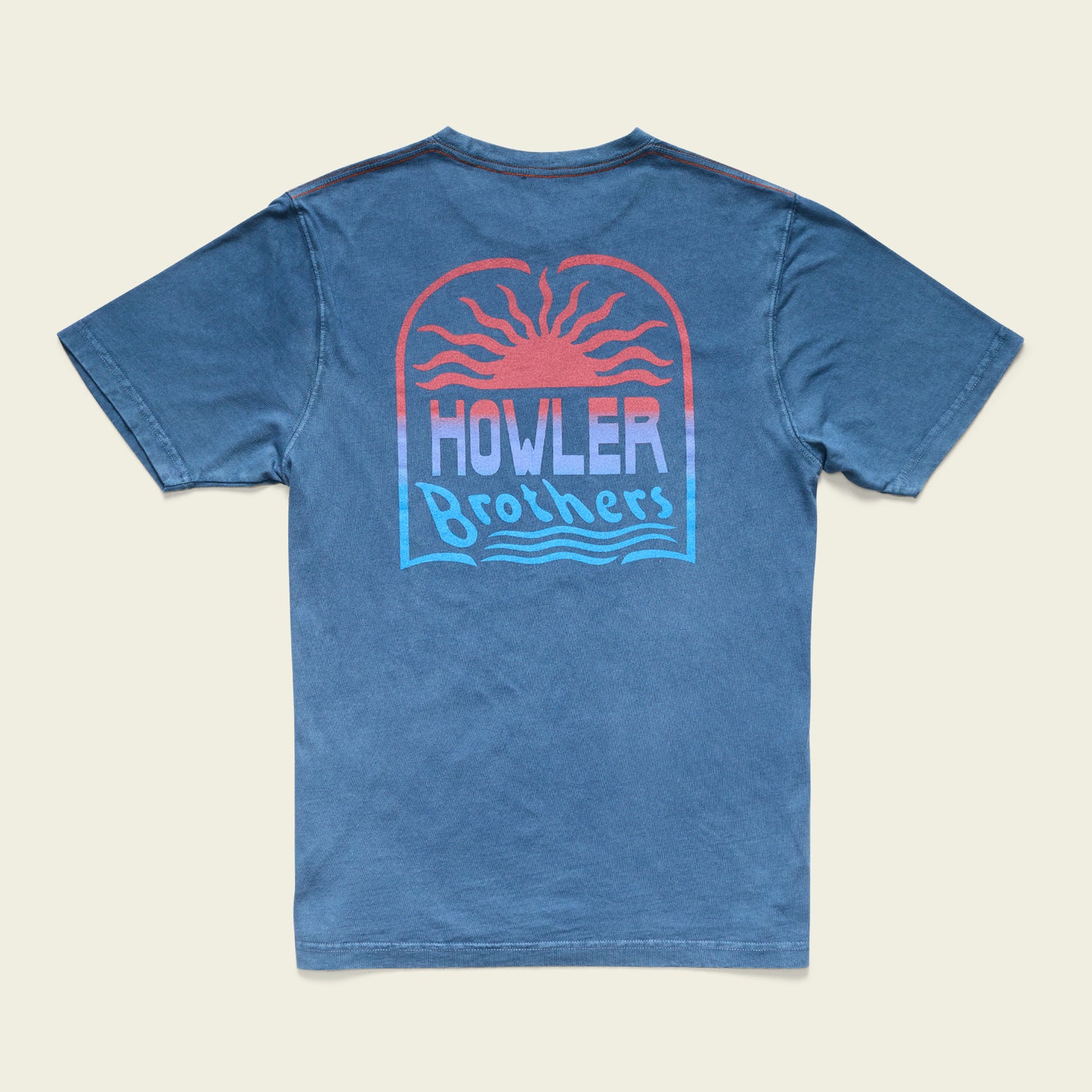 A blue cotton t-shirt featuring a graphic on the back of a setting sun with red and orange rays, above the text Howler Brothers in stylized font with wavy lines underneath, finished with a resin-washed vintage look.
