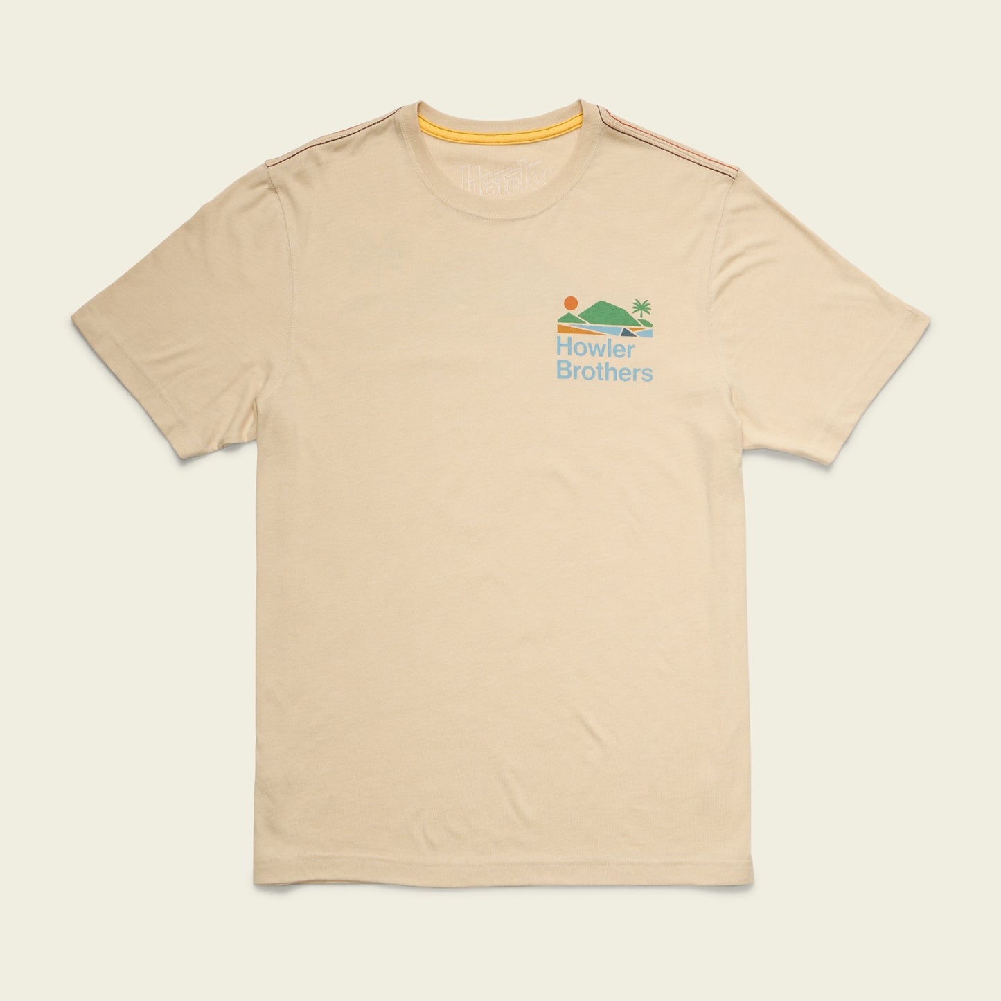 Beige short-sleeve t-shirt with a small colorful graphic of a sun, water, and palm tree above the words Howler Brothers on the left chest. Made from a soft cotton-poly blend for maximum comfort, with subtle orange stripes on the shoulders.