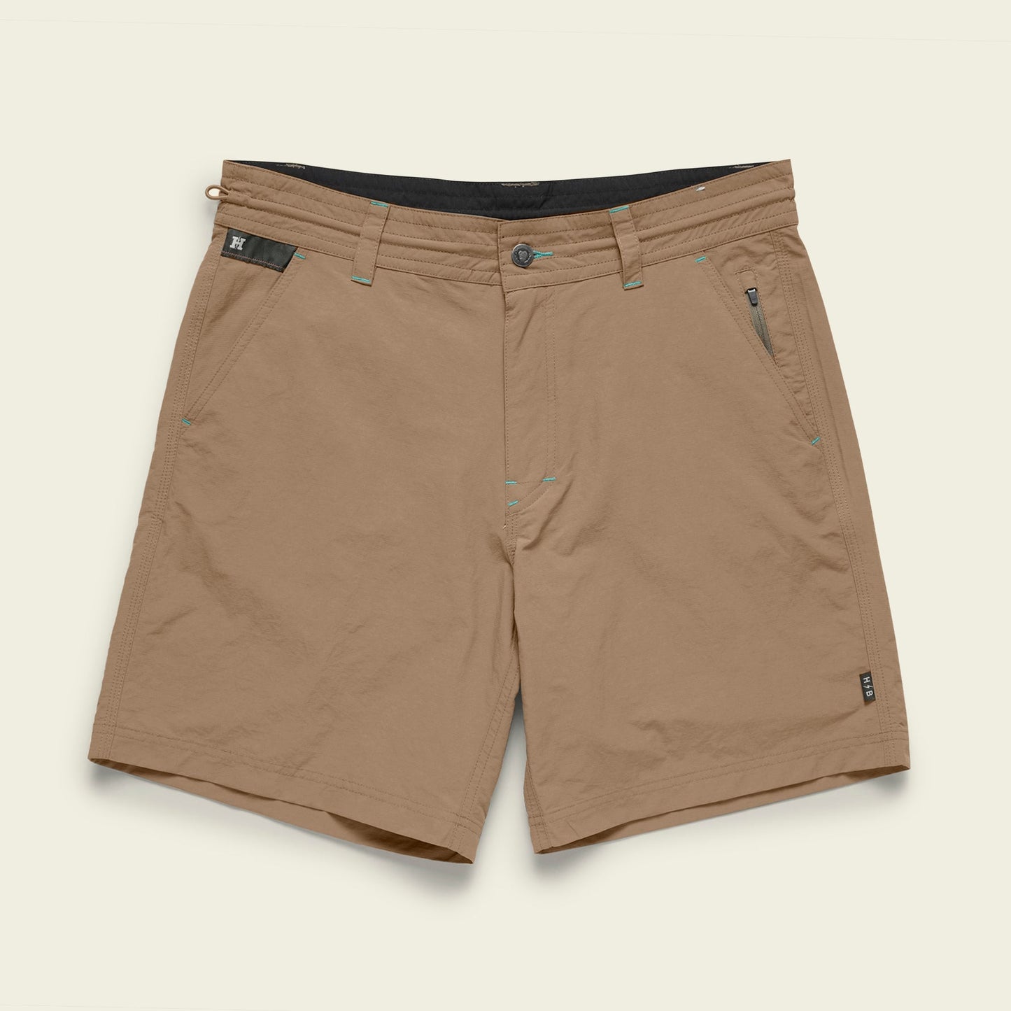 The Horizon Hybrid Shorts are a pair of tan-colored versatile shorts made from durable ripstop fabric, featuring front and zippered side pockets, belt loops, and a button closure, displayed against a plain light background.