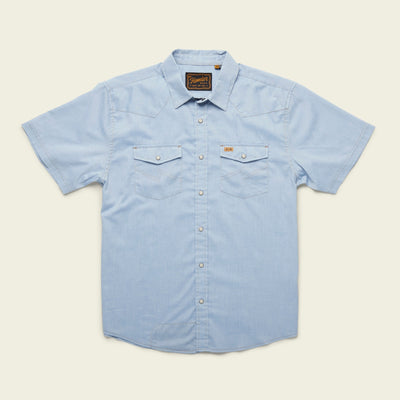 Light blue short-sleeve H Bar B snapshirt with pearl snaps, two front chest pockets, a pointed collar, and a small brown label above the left pocket, laid flat on a cream background.