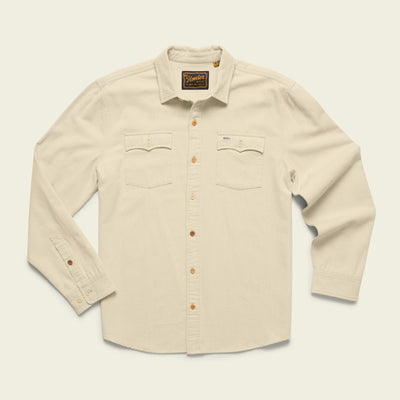 A cream-colored Novato Shirt, this western shirt features long sleeves, two chest pockets, and brown buttons, displayed on a plain light background.